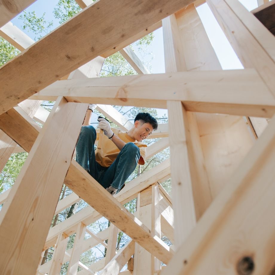 Illustrative licensed photograph: Carpenter working on framing at a home building site