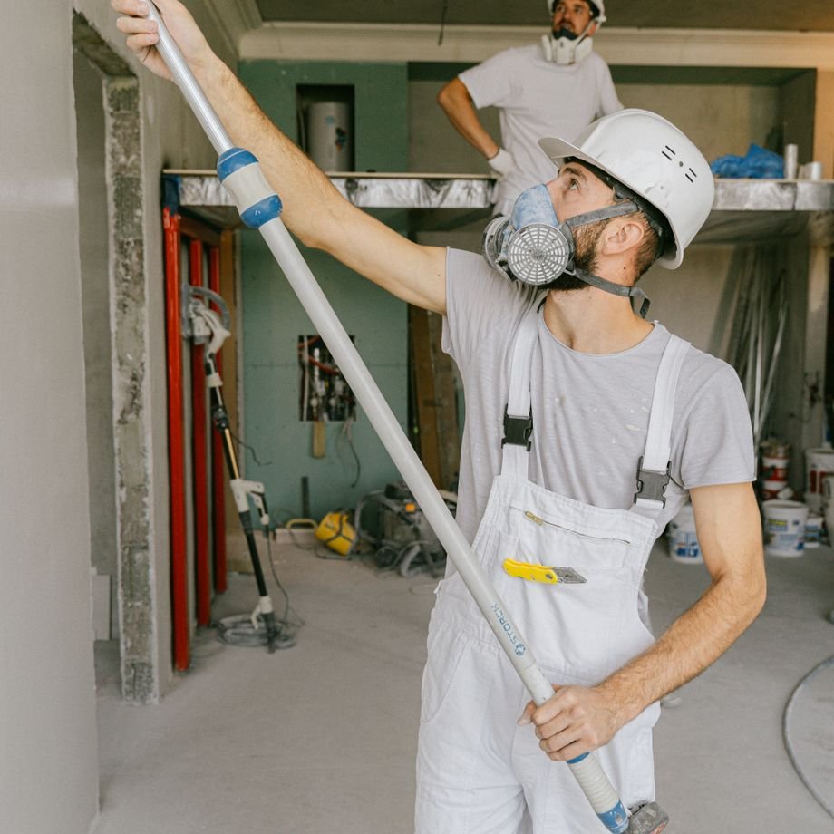 Illustrative licensed photograph: Contractors painting walls during interior renovation