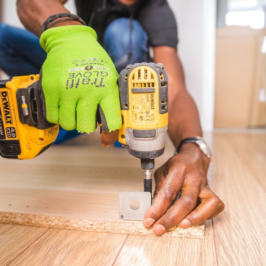 Illustrative licensed photograph: Carpenter using a power driver on wood