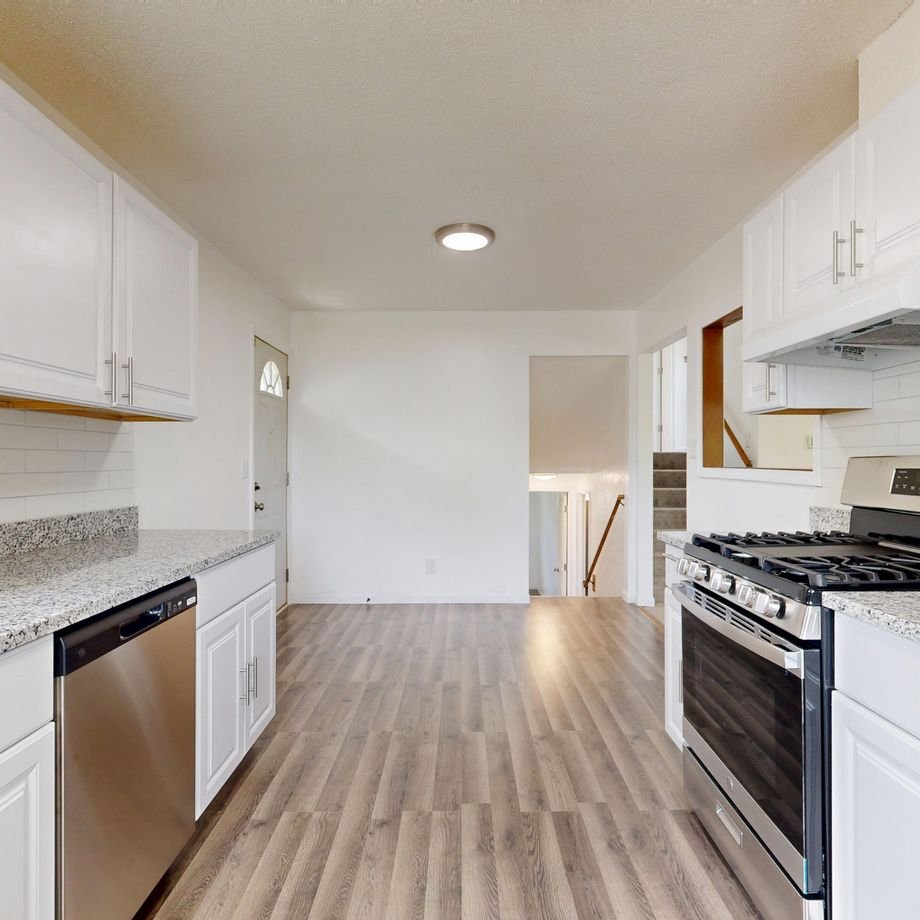 Illustrative licensed photograph: Clean white kitchen in a renovated home
