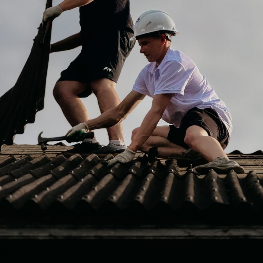 Illustrative licensed photograph: Roofing contractors repairing house roof