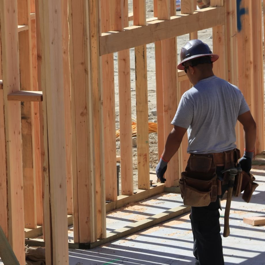 Illustrative licensed photograph: Carpenter at residential house framing site