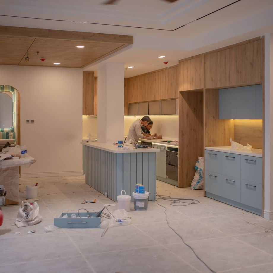 Illustrative licensed photograph: Construction worker renovating modern kitchen interior