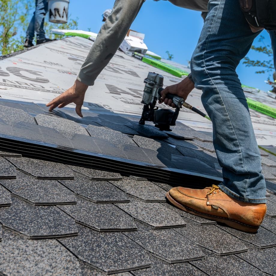 Illustrative licensed photograph: Roofer using nail gun