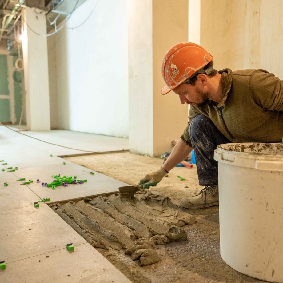 Illustrative licensed photograph: Contractor installing tile